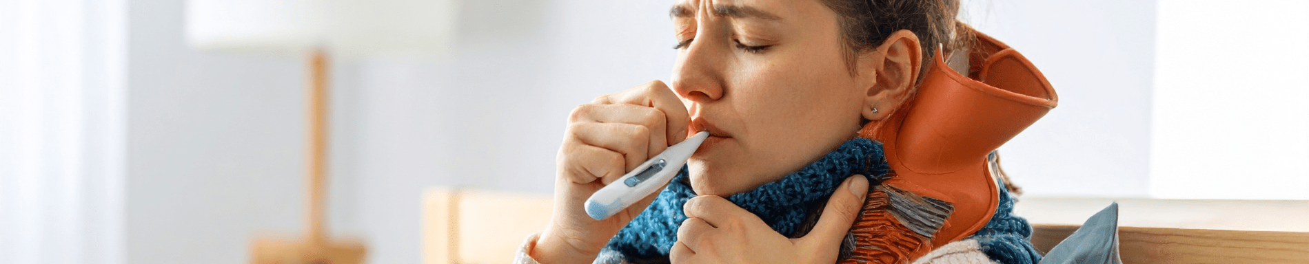 Patient using a thermometer to check body temperature during illness